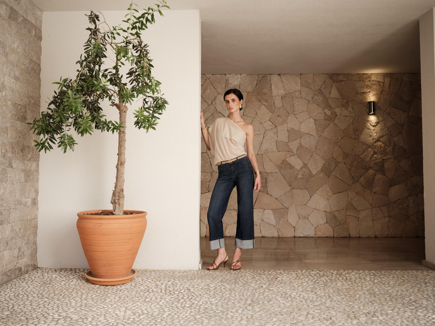 Frau in Damenmode vor einer Steinwand