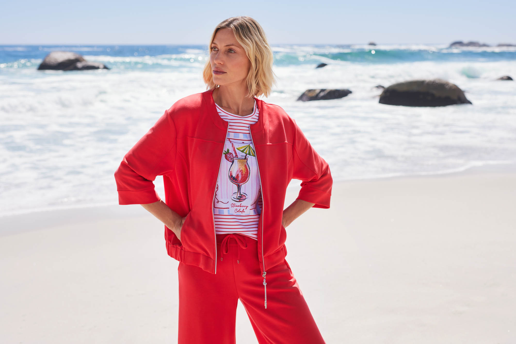 Frau in roter Sommerkleidung am Meer